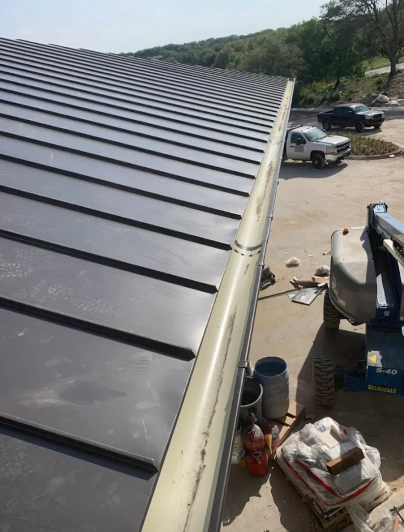 Standing seam panel and gutter detail on a metal roofing jobsite in Dothan